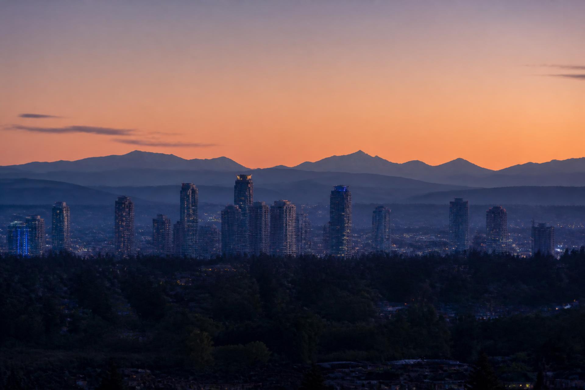 The Surrey, British Columbia skyline at dusk with the Coast Mountains behind it